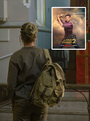 A woman seen from behind wearing an olive green military-style jacket and carrying a large olive green backpack, standing near an outdoor staircase. A movie poster for 'The Old Guard 2' is superimposed in the top right corner.